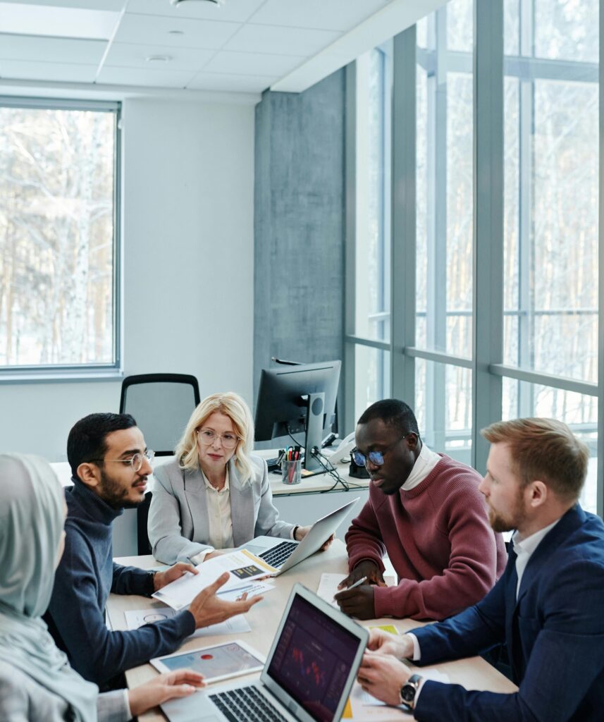 A diverse group of colleagues working together on a project in a bright, modern office environment.